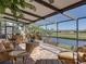 Well-furnished screened lanai with ample seating and a lovely view of the water and landscaping at 4115 Muirfield Loop, Lake Wales, FL 33859