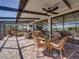 Expansive screened-in patio featuring comfortable seating, ceiling fans, and a picturesque water view at 4115 Muirfield Loop, Lake Wales, FL 33859