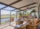 Screened-in patio provides a peaceful outdoor living area with comfortable seating and a pond view at 4115 Muirfield Loop, Lake Wales, FL 33859