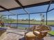 Screened lanai with cozy furniture, a fire pit, and scenic waterfront views, ideal for outdoor living at 4115 Muirfield Loop, Lake Wales, FL 33859