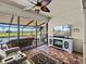 Well-lit sunroom with comfortable seating area and a great view of the backyard and pond at 4115 Muirfield Loop, Lake Wales, FL 33859