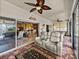 Relaxing sunroom boasts a ceiling fan, brick floors, and outdoor access to the lovely backyard at 4115 Muirfield Loop, Lake Wales, FL 33859