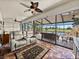 Spacious sunroom with ceiling fan, brick floors, leather sofa, and water views at 4115 Muirfield Loop, Lake Wales, FL 33859