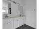 Modern bathroom featuring a double vanity with white cabinets and bright mirrors at 412 Savanna Pointe St, Winter Haven, FL 33884