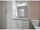 Light bathroom with a white vanity, gray granite countertops, and a decorative mirror at 42 Mountain Dr, Babson Park, FL 33827