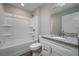 Light bathroom with a shower-tub and white vanity with gray granite countertops at 42 Mountain Dr, Babson Park, FL 33827