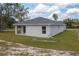View of the back of the house showing the covered porch, windows, and well-maintained lawn at 42 Mountain Dr, Babson Park, FL 33827