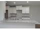 Bright open kitchen with white cabinets, gray granite countertops, and a stainless steel sink at 42 Mountain Dr, Babson Park, FL 33827
