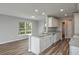 Bright kitchen with white cabinets, granite countertops, and an island, complemented by wood-look flooring at 42 Mountain Dr, Babson Park, FL 33827