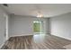 Living room featuring wood-look floors, a ceiling fan, and large sliding glass doors for natural light at 42 Mountain Dr, Babson Park, FL 33827