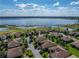 Stunning aerial view showcasing a lakefront residential area surrounded by lush greenery and neighborhood amenities at 4232 Roebelenii Dr, Lake Wales, FL 33859