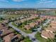 Aerial view of a well-maintained neighborhood featuring single-Gathering homes with mature landscaping near a lake at 4232 Roebelenii Dr, Lake Wales, FL 33859