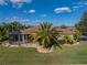 A perfectly manicured lawn and meticulously landscaped yard featuring a screened lanai at 4232 Roebelenii Dr, Lake Wales, FL 33859