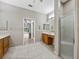 Bright bathroom features tile flooring, a glass shower, and wood vanity with ample counter space at 4232 Roebelenii Dr, Lake Wales, FL 33859
