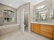 This bathroom features double vanity, bathtub, a ceiling fan, and natural light at 4232 Roebelenii Dr, Lake Wales, FL 33859