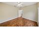 This bedroom features wood floors, a ceiling fan, and access to another room at 4232 Roebelenii Dr, Lake Wales, FL 33859