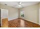 This bedroom features wood floors, a ceiling fan, and a window letting in natural light at 4232 Roebelenii Dr, Lake Wales, FL 33859