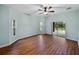 This bedroom features wood floors, a ceiling fan, and sliding glass doors to the outside at 4232 Roebelenii Dr, Lake Wales, FL 33859