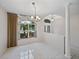 Airy dining area with neutral walls, chandelier, tile floors, and light-filled windows at 4232 Roebelenii Dr, Lake Wales, FL 33859