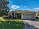 Charming home with a well-manicured lawn, mature landscaping and brick-paved driveway leading to the attached two-car garage at 4232 Roebelenii Dr, Lake Wales, FL 33859