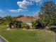 Beautiful backyard featuring a neutral exterior paint color, lush landscaping, and manicured lawn at 4232 Roebelenii Dr, Lake Wales, FL 33859