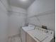 Functional laundry room with overhead shelving and a sink with white washer and dryer at 4232 Roebelenii Dr, Lake Wales, FL 33859