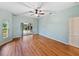 This main bedroom features wood floors, a ceiling fan, and sliding glass doors to the outside at 4232 Roebelenii Dr, Lake Wales, FL 33859