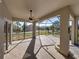 Enclosed patio features a ceiling fan and views of the lush landscaping and serene lake at 4232 Roebelenii Dr, Lake Wales, FL 33859