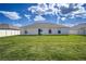 Exterior back of the house featuring a well-maintained lawn at 447 Lanham Dr, Winter Haven, FL 33881