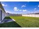 Large grassy backyard featuring a white vinyl fence at 447 Lanham Dr, Winter Haven, FL 33881