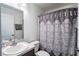 Clean bathroom with a patterned shower curtain, single sink vanity, and neutral tones at 447 Lanham Dr, Winter Haven, FL 33881