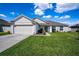 Charming single-story home with a well-manicured lawn and attached two-car garage at 447 Lanham Dr, Winter Haven, FL 33881