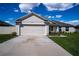 Home's spacious two-car garage and landscaped front yard at 447 Lanham Dr, Winter Haven, FL 33881