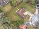 An aerial view of the property, with a spacious yard, curved driveway and lots of surrounding foliage at 4765 Lantern Ct, Orlando, FL 32808