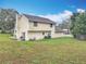 Back exterior view of the house showcasing large yard and home's siding at 4765 Lantern Ct, Orlando, FL 32808