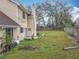 View of the backyard with a spacious lawn, partial fence, and a patio area at 4765 Lantern Ct, Orlando, FL 32808