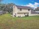 Back exterior view of the house showcasing the expansive yard and home's siding at 4765 Lantern Ct, Orlando, FL 32808