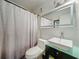Bright bathroom featuring a modern sink, lighted mirror, and white textured shower curtain at 4765 Lantern Ct, Orlando, FL 32808