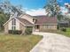 Charming home with driveway, brick and siding facade, and mature trees in the yard at 4765 Lantern Ct, Orlando, FL 32808