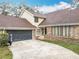 View of home, garage and driveway. The house is sided with brick on the lower level at 4765 Lantern Ct, Orlando, FL 32808