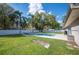 Relaxing backyard with a sparkling pool, mature trees, lush lawn, and privacy fence at 5115 Woodgreen Ln, Lakeland, FL 33811