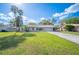 Inviting single-story home with lush green lawn and mature trees on a sunny day at 5115 Woodgreen Ln, Lakeland, FL 33811