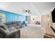 Spacious living area with a plush gray sectional, a ceiling fan, and an open view to the dining room at 5115 Woodgreen Ln, Lakeland, FL 33811