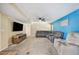 Bright living room featuring a gray sectional sofa, TV, and modern ceiling fan at 5115 Woodgreen Ln, Lakeland, FL 33811
