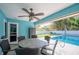 View of patio seating area with ceiling fan, next to sparkling in-ground pool with beautiful backyard views at 5115 Woodgreen Ln, Lakeland, FL 33811