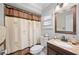 Bathroom featuring shower with patterned curtain, toilet, and vanity with decorative countertop at 513 Kelsey St # 513, Lakeland, FL 33803