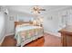 Comfortable bedroom with hardwood floors, ceiling fan, and a cozy bed with patterned bedding at 513 Kelsey St # 513, Lakeland, FL 33803