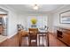 Sunlit dining room with wood table and seating for six, complemented by flowers and wood floors at 513 Kelsey St # 513, Lakeland, FL 33803