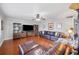 Inviting living room with a brown leather sectional sofa, entertainment center, and rich wood flooring at 513 Kelsey St # 513, Lakeland, FL 33803