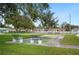 Shuffleboard court with benches is surrounded by green grass and other neighborhood houses at 513 Kelsey St # 513, Lakeland, FL 33803